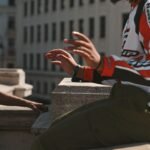 a man with dreadlocks sitting on a ledge